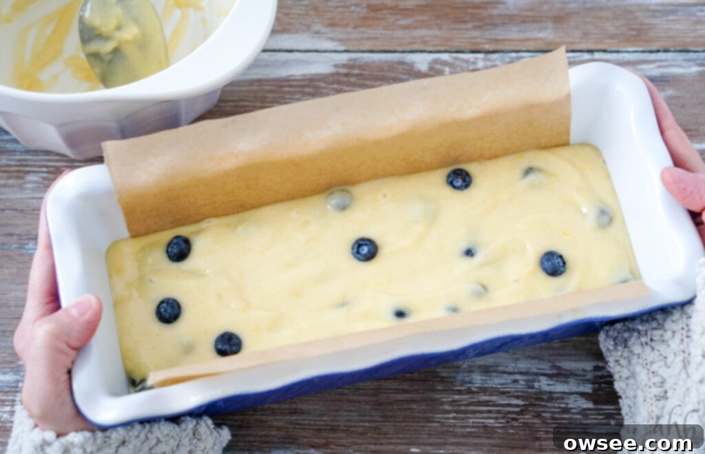 Zesty Lemon Blueberry Bread Drizzled with Buttermilk Glaze 5 A loaf pan lined with parchment paper and filled with lemon blueberry bread batter, ready for baking. This ensures easy removal and a clean bake.