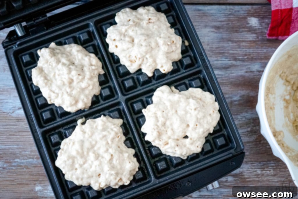 Homestyle Oatmeal Waffles 7 Pouring oatmeal waffle batter into a hot waffle maker.