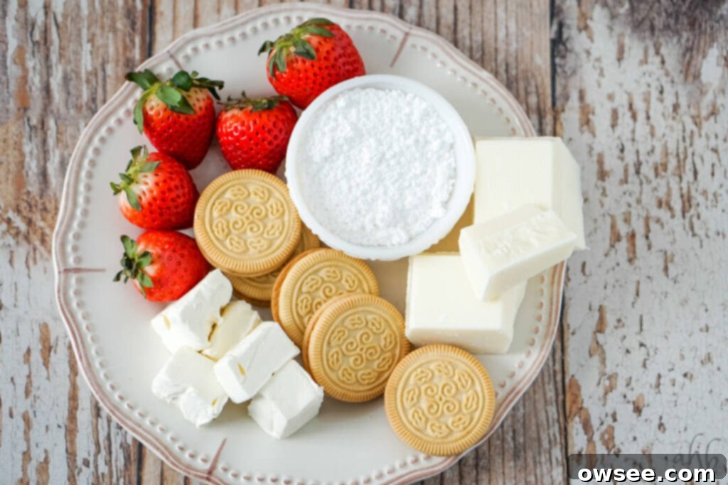 Easy Strawberry Cheesecake Truffles 4 Ingredients laid out for strawberry cheesecake truffles, including vanilla sandwich cookies, strawberries, cream cheese, powdered sugar, and almond bark.