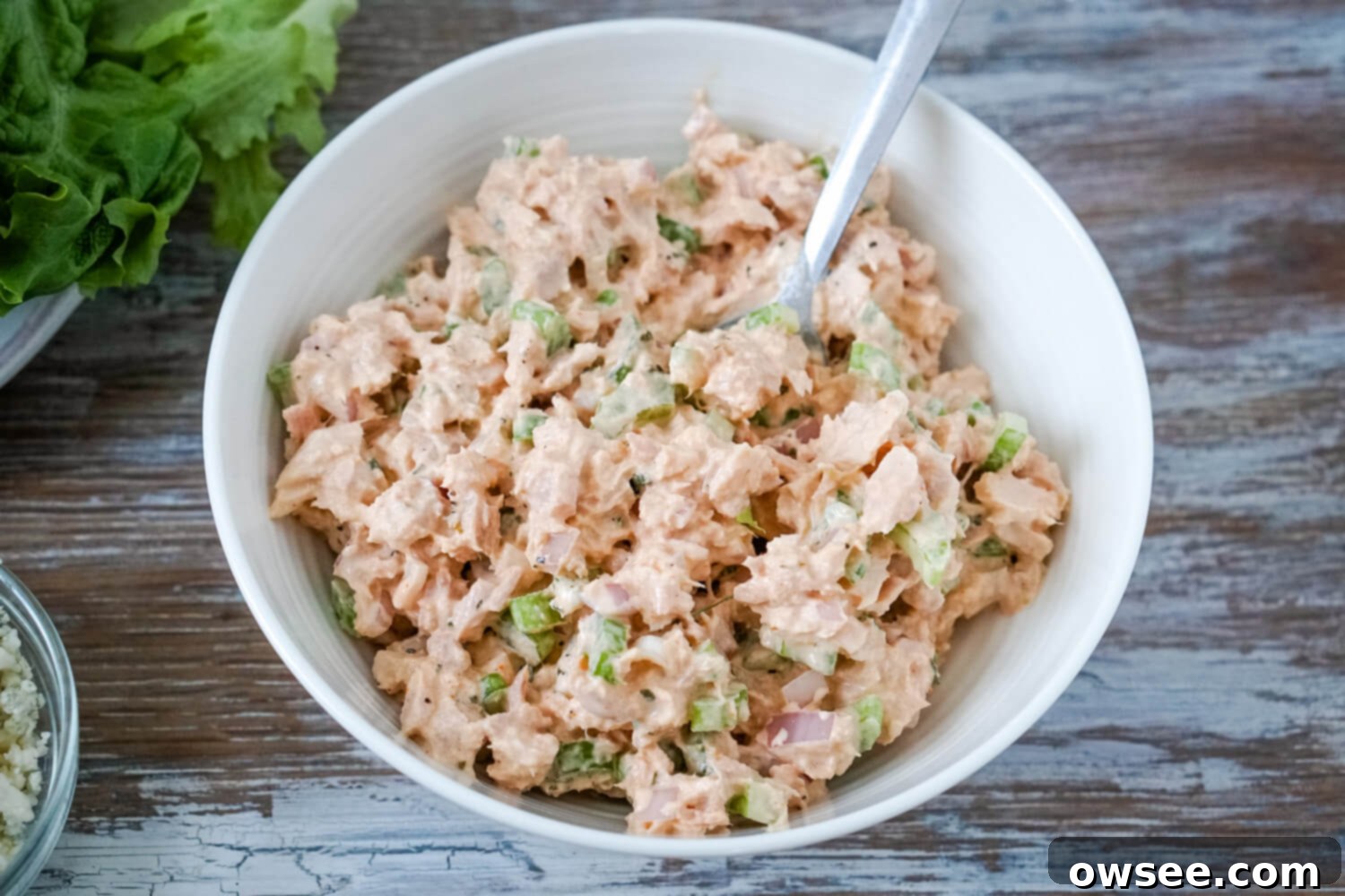 Kickin' Buffalo Tuna 8 A white bowl full of buffalo tuna salad with a plate of lettuce leaves to one side.