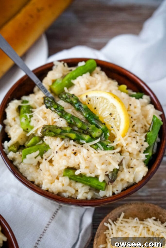 Creamy Instant Pot Asparagus Risotto 2 A bowl of creamy Instant Pot Asparagus Risotto garnished with fresh asparagus and lemon slices.
