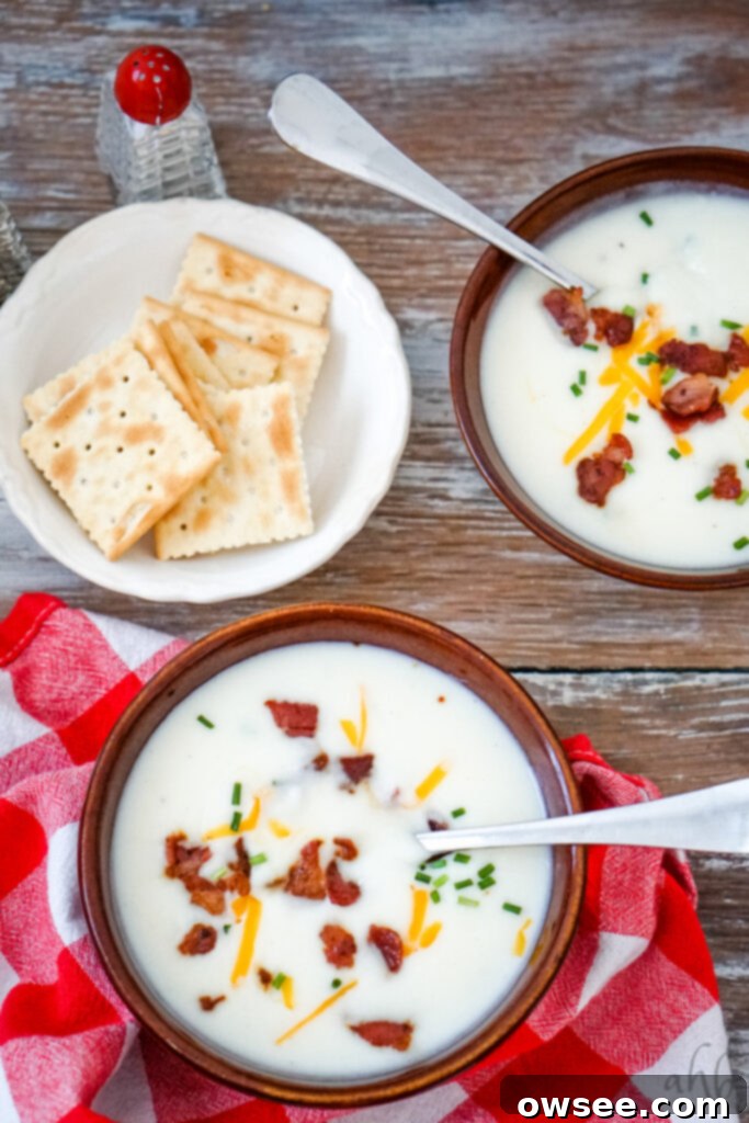 Effortless Four-Ingredient Potato Soup 3 Two bowls of 4 ingredient potato soup with a white bowl of saltine crackers.
