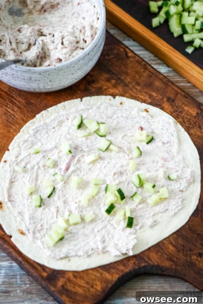 Tuna Roll-Ups 8 The creamy tuna mixture is meticulously spread onto a large flour tortilla, then topped with a generous layer of diced cucumbers for texture and freshness.